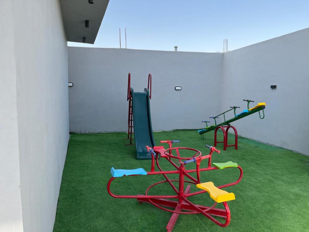 a room with two swings and a playground at عمان البحر الميت in Sowayma
