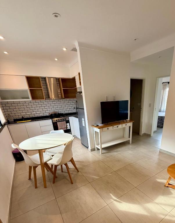 a kitchen and living room with a table and chairs at Departamento céntrico in Olavarría