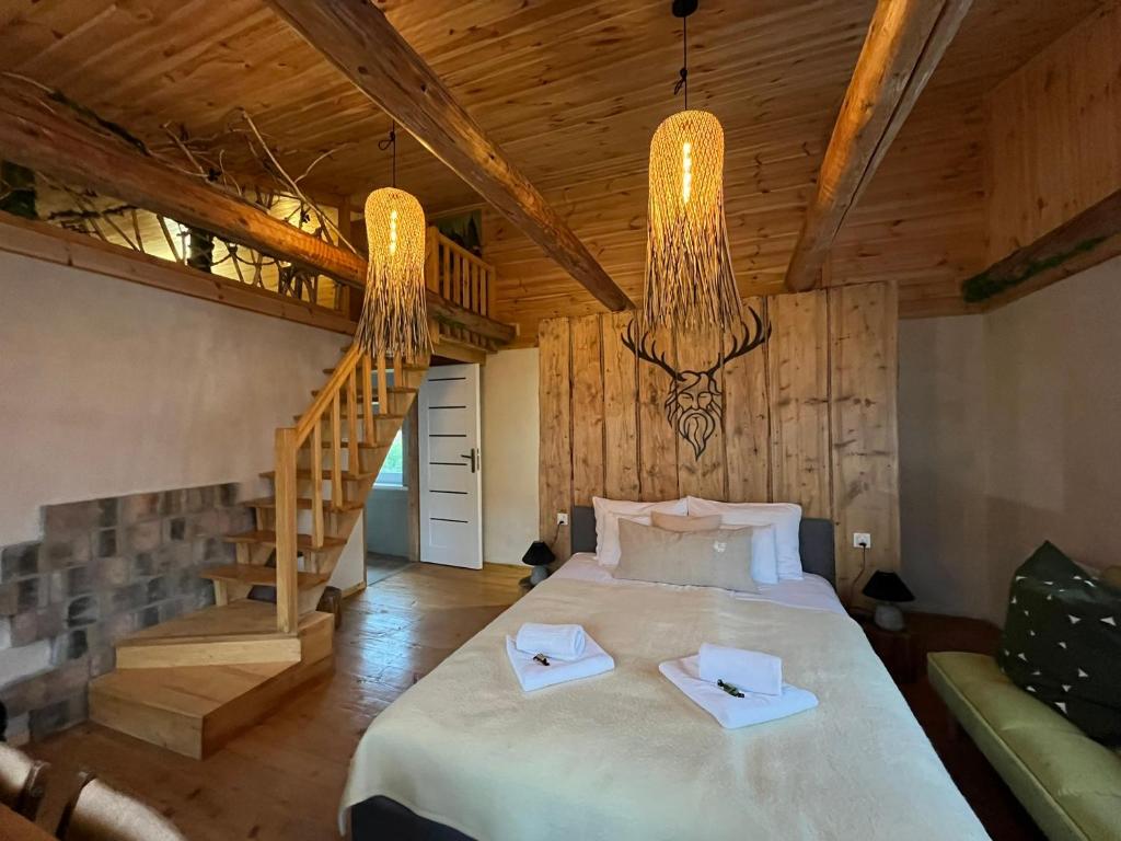 a bedroom with a large bed and a staircase at Wąkop 6 Agroturystyka Eco in Nowa Słupia