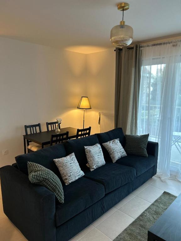 a blue couch with pillows in a living room at Chic 2 chambres appartement proche de Paris in Vitry-sur-Seine