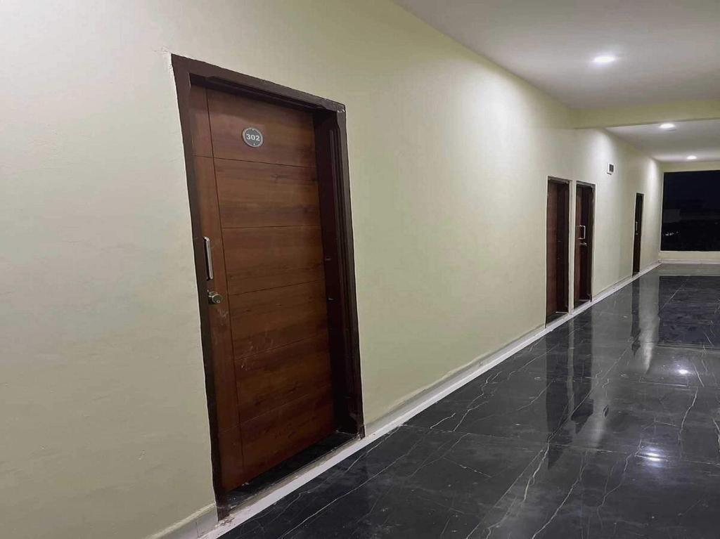 a hallway with a wooden door in a building at Hotel O Pravin Executive in Latur