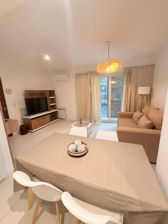 a living room with a table and chairs and a couch at Segundo hogar in Luján