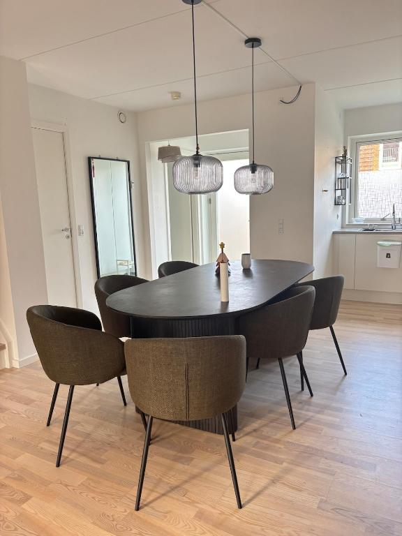 een eetkamer met een zwarte tafel en stoelen bij Cozy Townhouse near Copenhagen in Rødovre