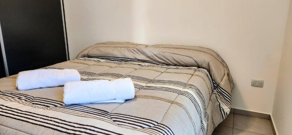 a bed with two pillows on it in a room at Alojamiento Mavic - Amueblados Comahue in Cipolletti