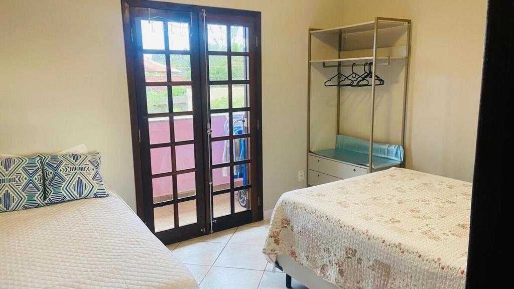 a bedroom with a bed and a sliding glass door at Apartamento Ilha Comprida in Ilha Comprida