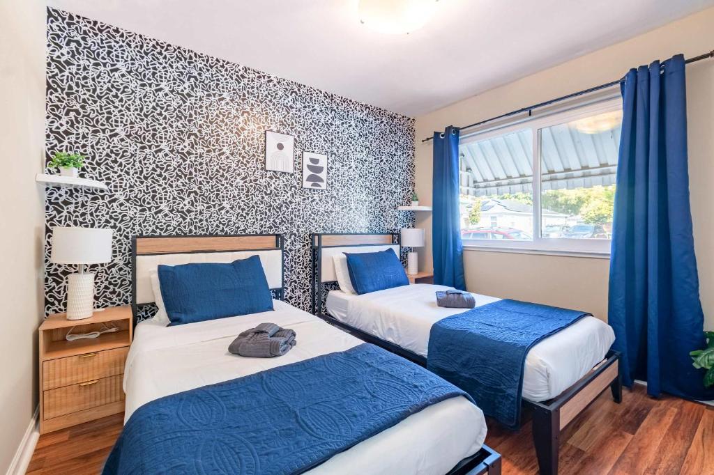 バークレーにあるNew Modern 2BR Berkeley Retreat - Near UC & Parkのブルーカーテン付きのホテルルーム内のベッド2台