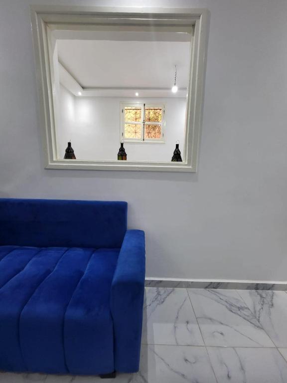 a blue couch in a room with a mirror at Stylish Moroccan Apartment in Marrakesh