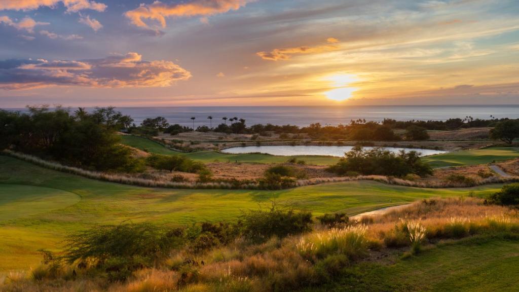 une vue d'un parcours de golf avec le coucher de soleil en arrière-plan dans l'établissement Mauna Kea Palms Ocean Views Stunning Mauna Kea Resort Best Beaches, à Waimea