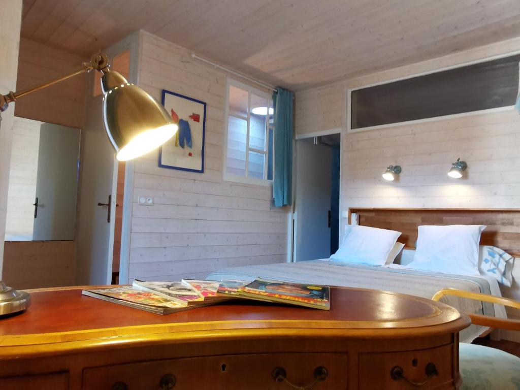 a bedroom with a bed and a desk with a lamp at Maison cosy avec cour privative au cœur de l'Auvergne - FR-1-582-316 in Lempdes sur Allagnon