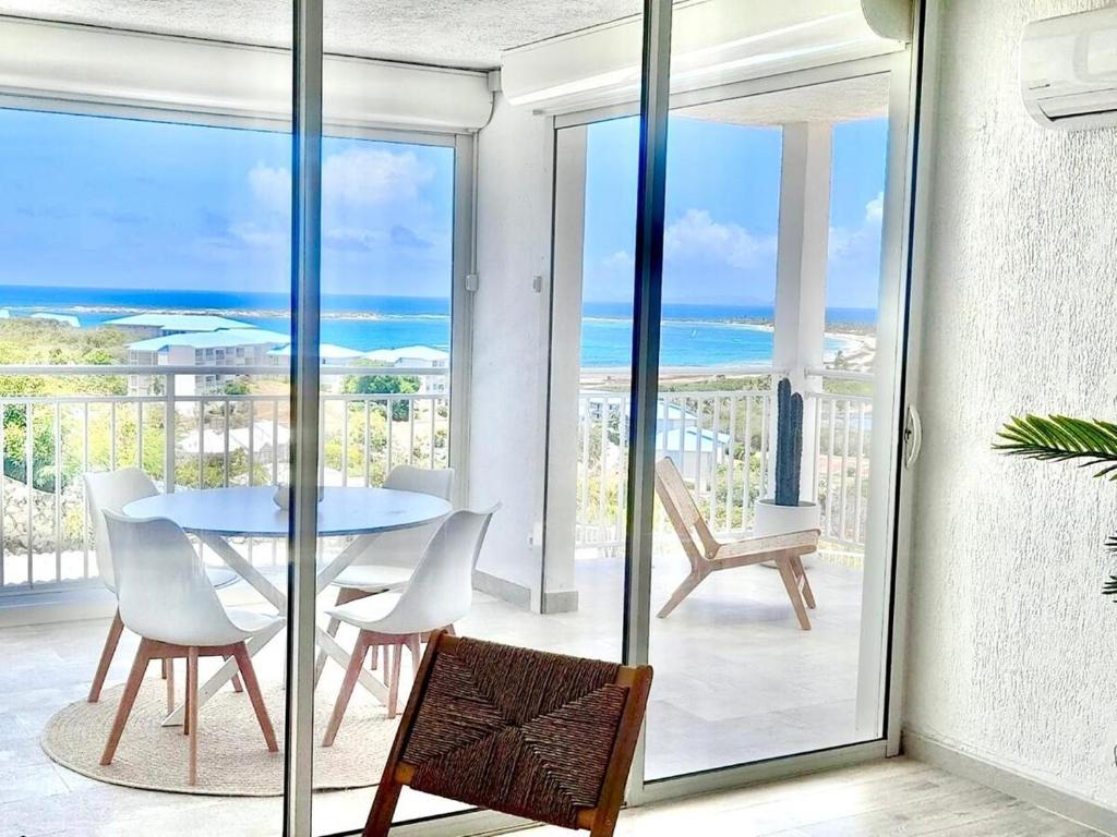a dining room with a table and a view of the ocean at Breathtaking view, comfort & ideal location in Saint Martin