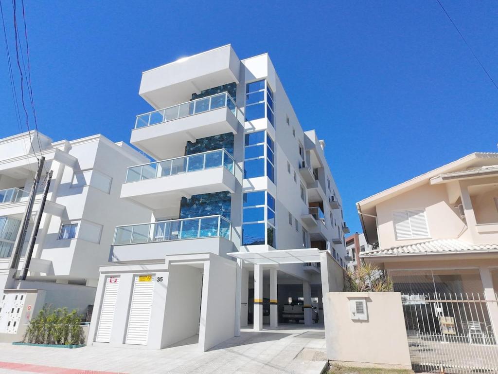 a white apartment building with blue balconies at palmas beach in Governador Celso Ramos