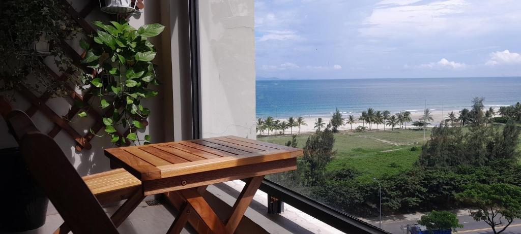 a table on a balcony with a view of the beach at Beachfront Luxury Apartment in Altara Building - Da Nang in Da Nang