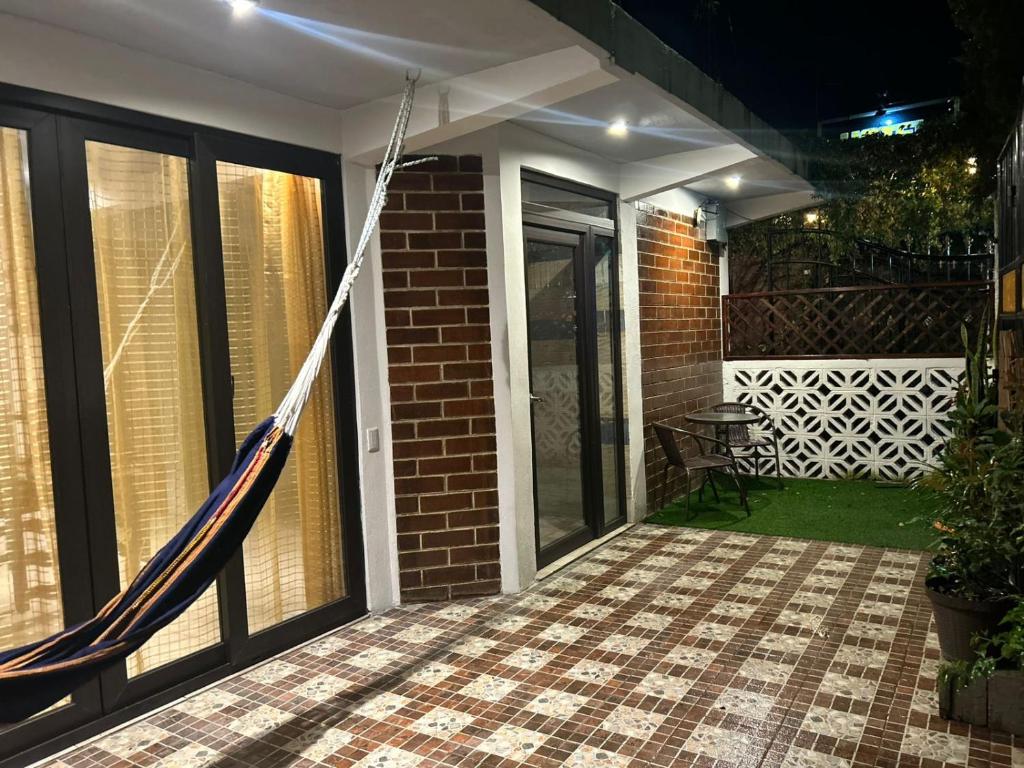 a porch with a hammock outside of a house at Casa Garden in San Pedro La Laguna