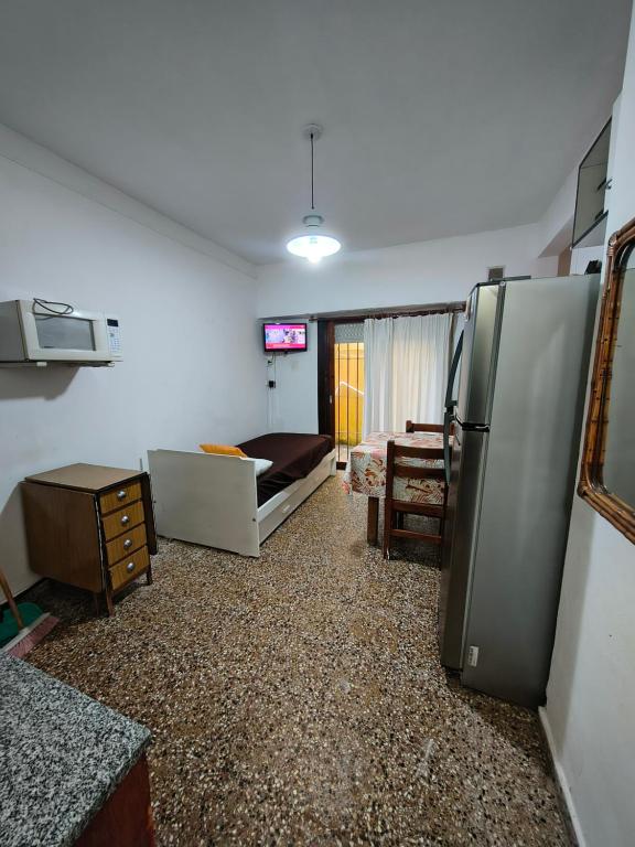 Una sala de estar con refrigerador y un dormitorio. en Alquiler de verano - San Bernardo, en San Bernardo