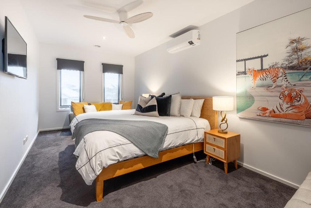 a bedroom with a bed and a painting on the wall at Stylish Coastal Retreat in Ocean Grove