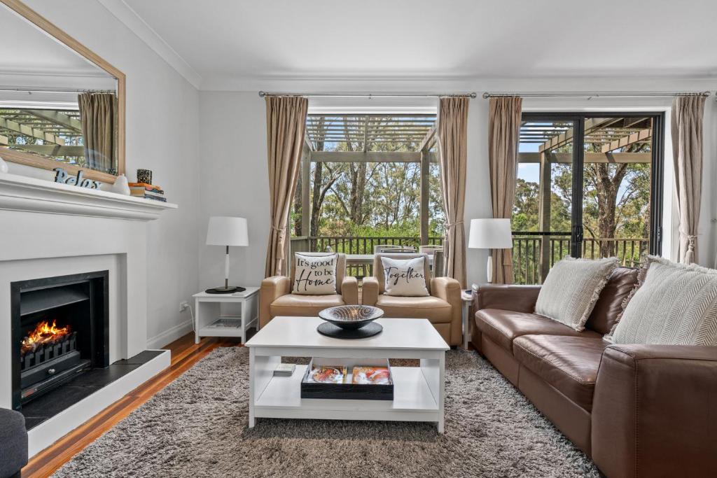 波高尔宾Villa Piccola Casa, Premier 2 Storey Villa, 2 Bedrooms, both with private ensuites, with third toilet on the ground floor的带沙发和壁炉的客厅