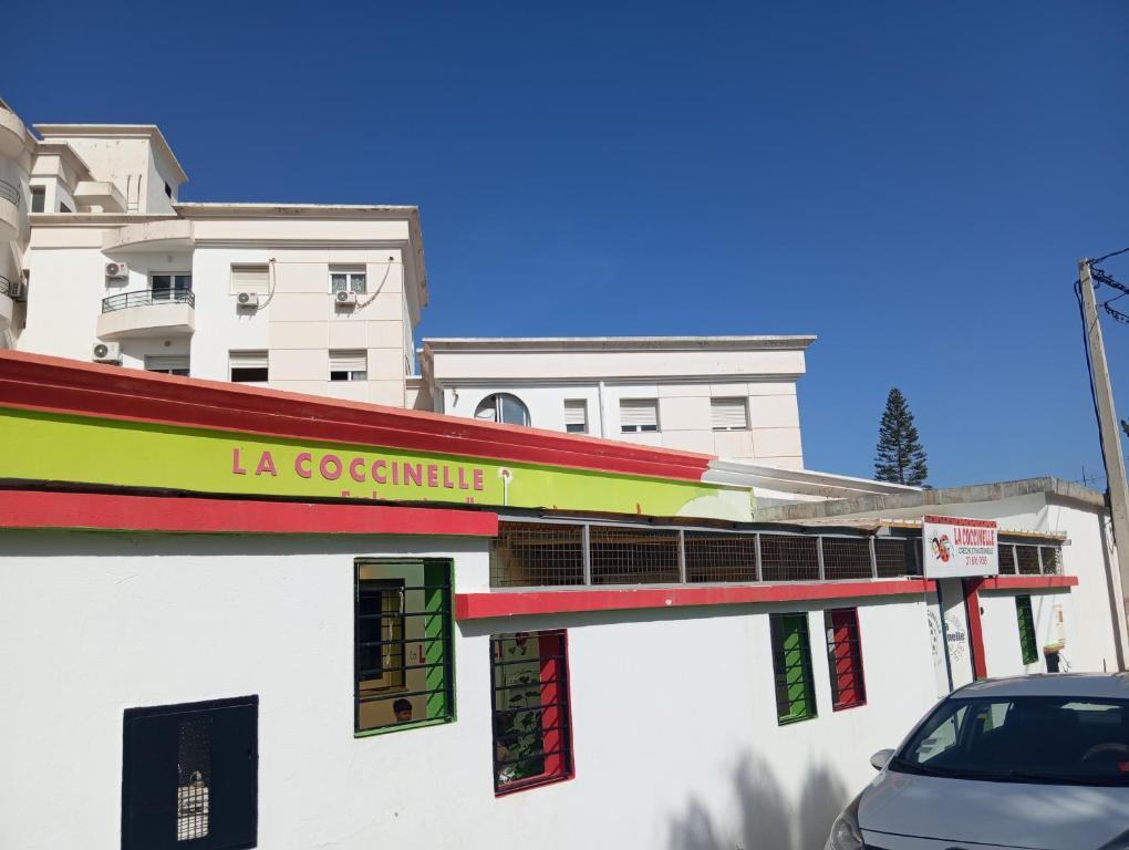 a building with a la costanza sign on it at Guest Room Near Airport in Ariana