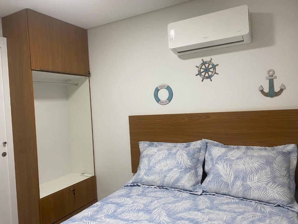 um quarto com uma cama com cabeceira de madeira em Tamandaré Mar de Campas Flat 218 Carneiros em Tamandaré