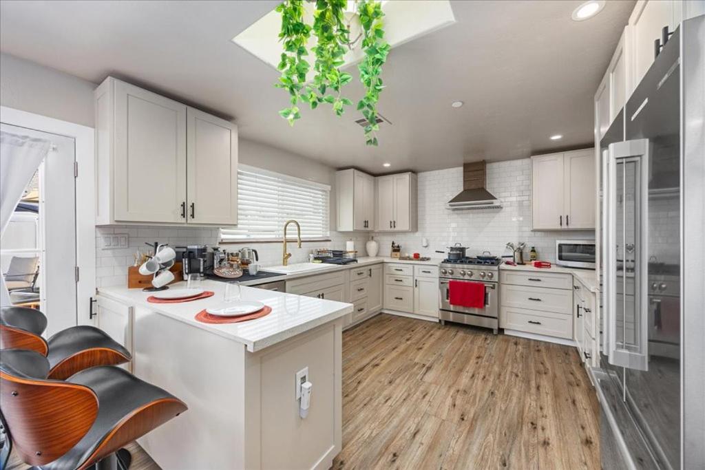 een grote keuken met witte kasten en een keukeneiland bij KingBeds Skylight 1GB Wi-Fi Step-free Clean in Bakersfield