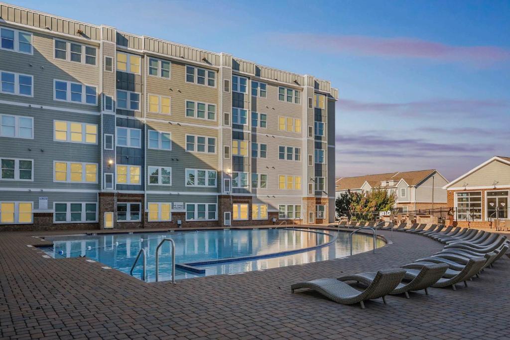 un immeuble avec une piscine devant un immeuble dans l'établissement Modern Comfort and Resort Style Living Near CU, à Sunny Acres