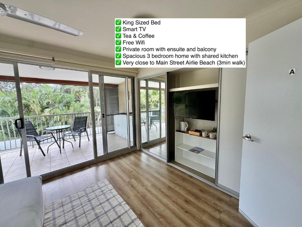 een woonkamer met glazen schuifdeuren bij Ocean Aura Room A in Airlie Beach