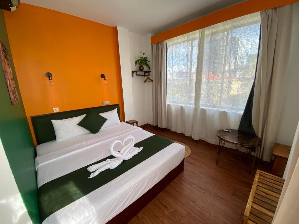 a bedroom with a bed with a white ribbon on it at Mad Monkey Hostel Phnom Penh in Phnom Penh