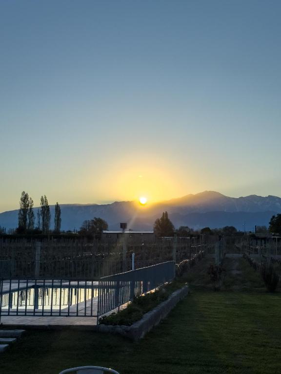 a sunset with the sun setting over the mountains at Casa Isolina in Ciudad Lujan de Cuyo