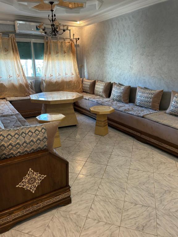 a living room with a couch and a table at Très bel appartement spacieux in Taza