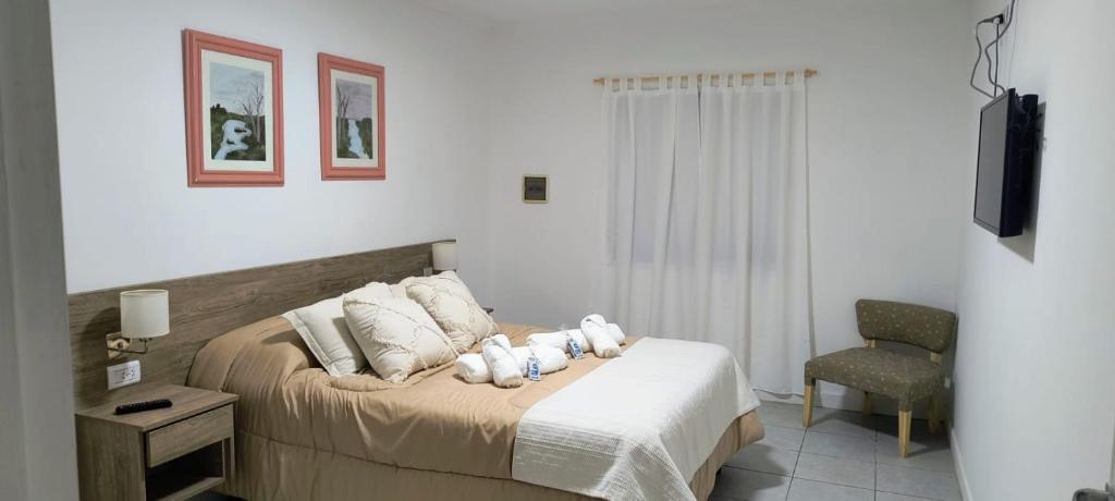 ein Schlafzimmer mit einem Bett mit zwei Stofftieren darauf in der Unterkunft CasaMar in General Villegas