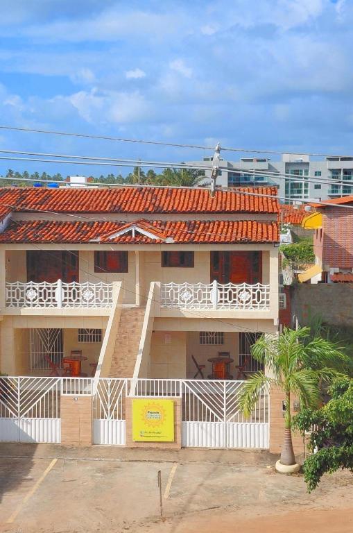 ein Gebäude mit einem Balkon und einem Mann darauf. in der Unterkunft Pousada Aconchego Sol e Mar in Maragogi