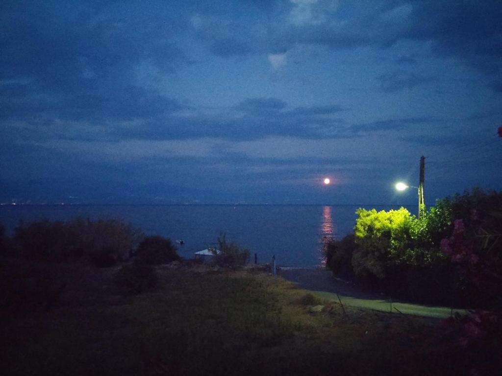 vistas al océano por la noche con luz de la calle en Bousounis Apartments, en Chrani