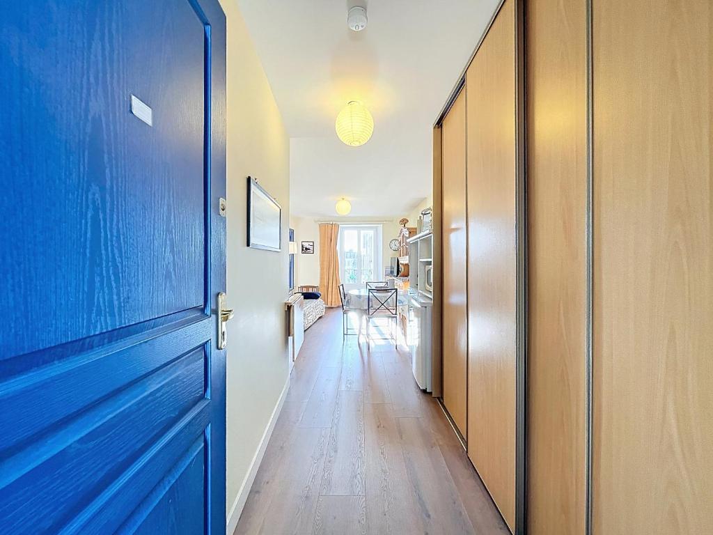 einen Flur mit blauer Tür und einer Küche in der Unterkunft Appartement T2 avec ascenseur, hypercentre, à 50m de la plage, WIFI, TV connectée, linge en option - FR-1-361-4 in Granville