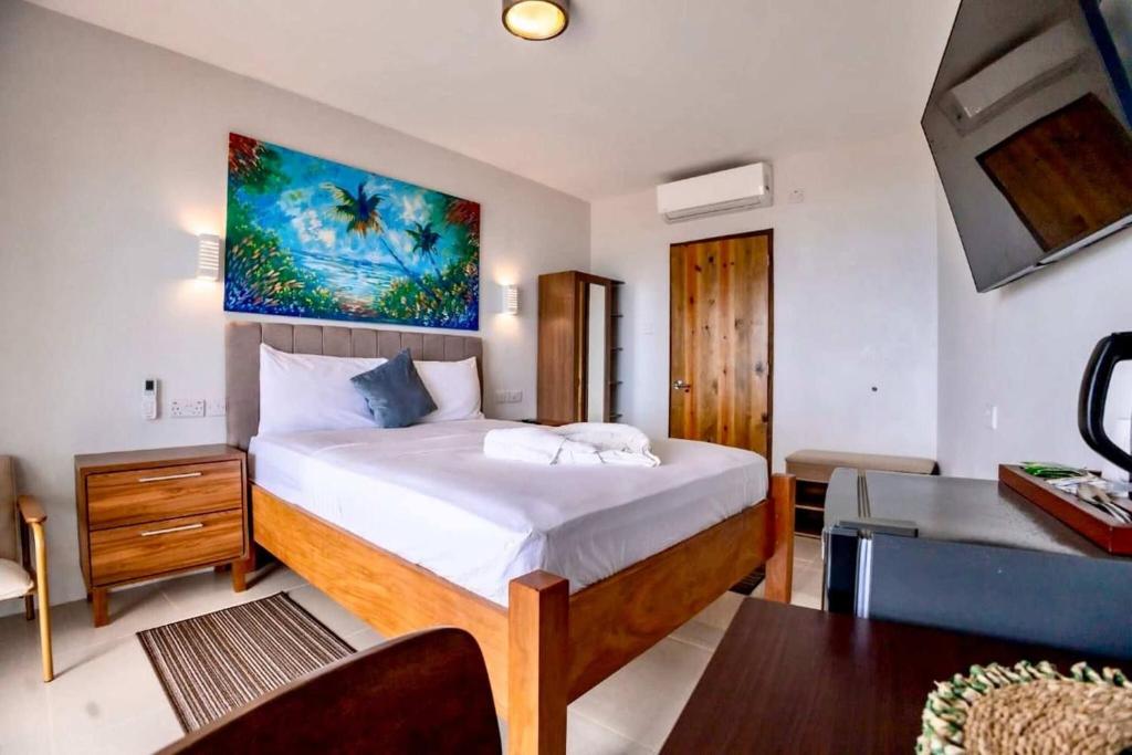 um quarto com uma cama e uma pintura na parede em Hammock Suite CoCo-Nut by ZenBreak em Charlotte