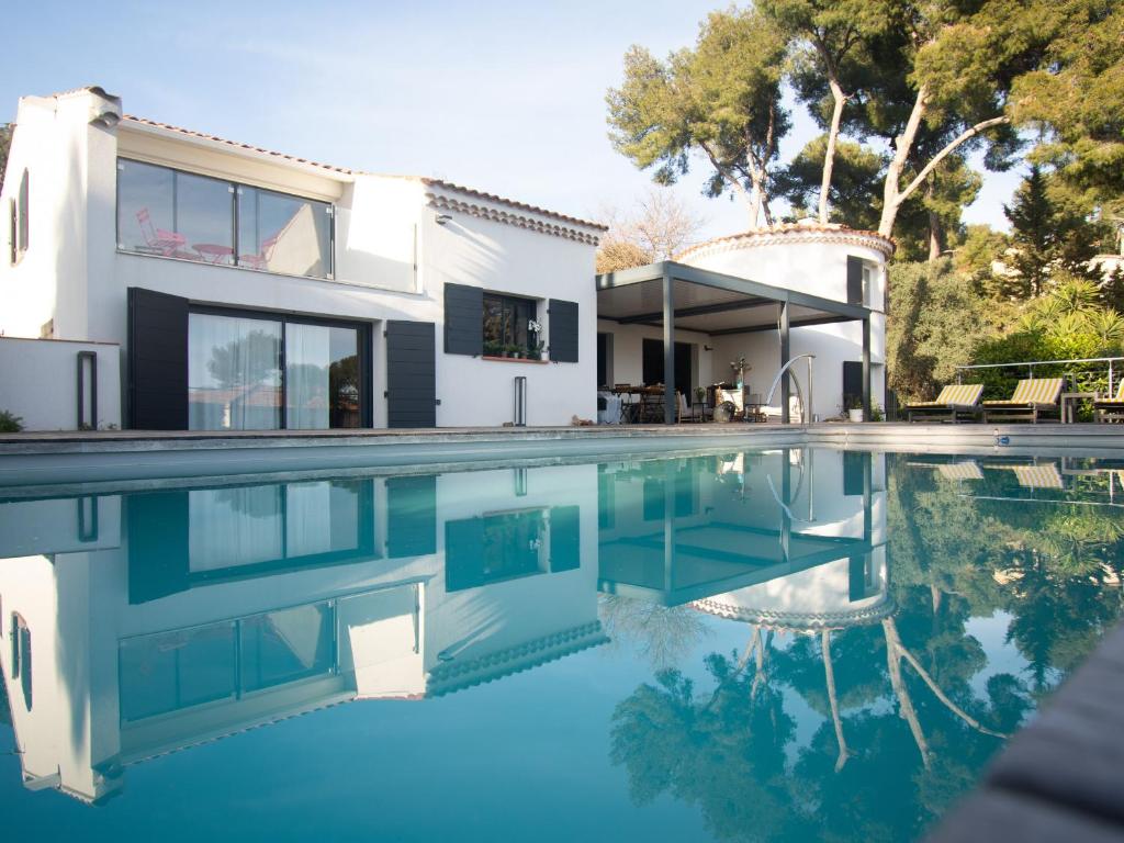 a house with a swimming pool in front of a house at Carqueiranne: Villa de Charme avec Piscine, Vue Mer, pour 8 Personnes - FR-1-599-119 in Carqueiranne