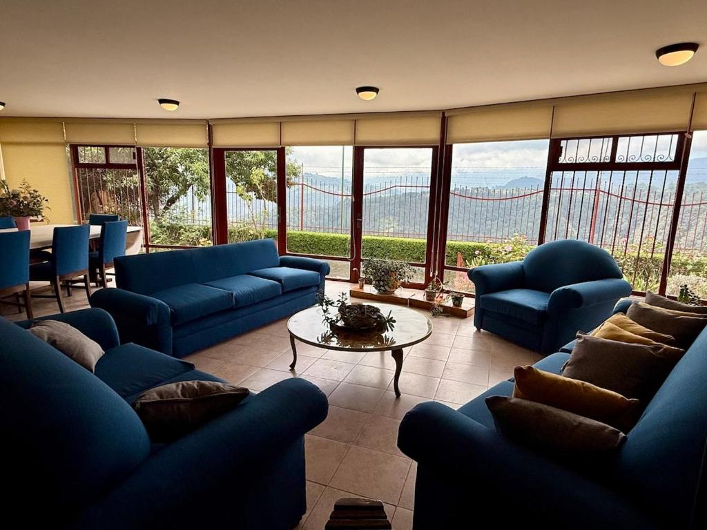 a large living room with blue couches and a table at Casa Sierravista in Zacatlán