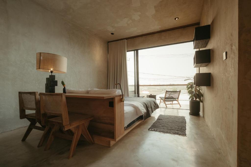 a bedroom with a desk and a bed and a window at The Iggy Hotel Seseh Studio 3 Sauna, Ice Bath in Cemagi