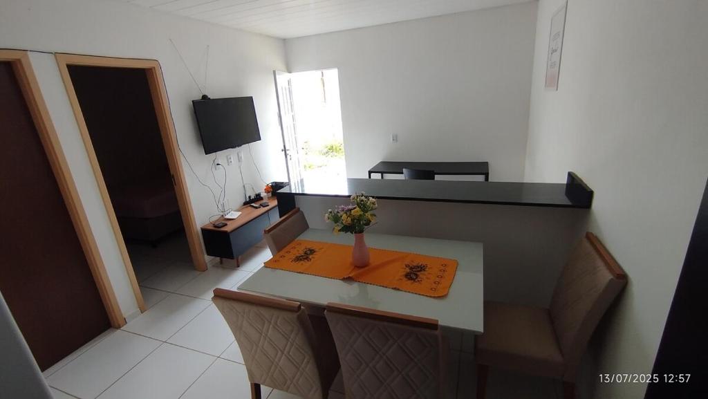 a small room with a table with a vase of flowers on it at Casa aconchegante em Garanhuns in Garanhuns