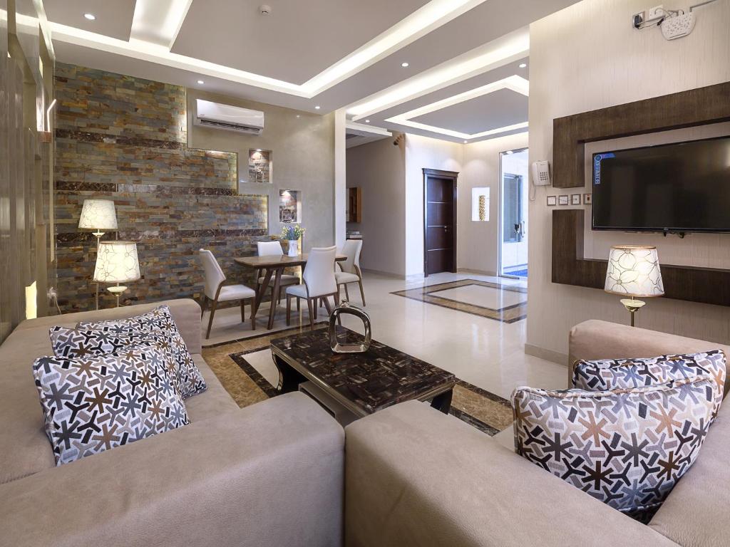 a living room with two couches and a tv at Aliah Apartment in Khamis Mushayt