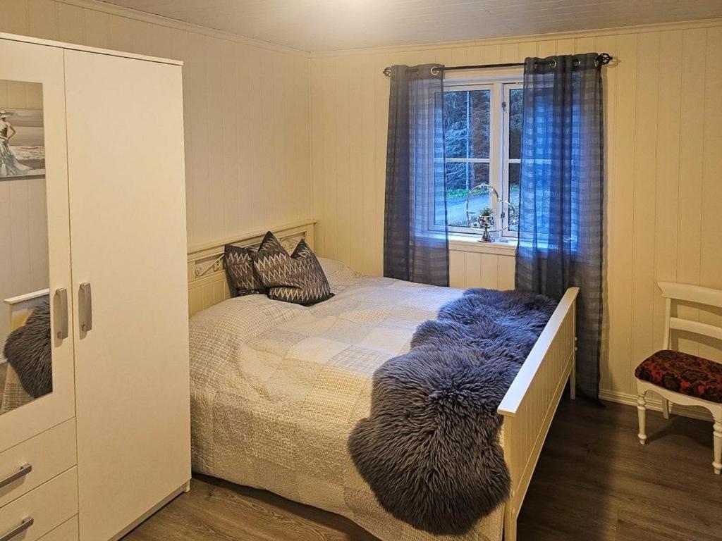 a bedroom with a bed with a blue blanket at Charming Farm Stay On Averøy Island in Lyngstad