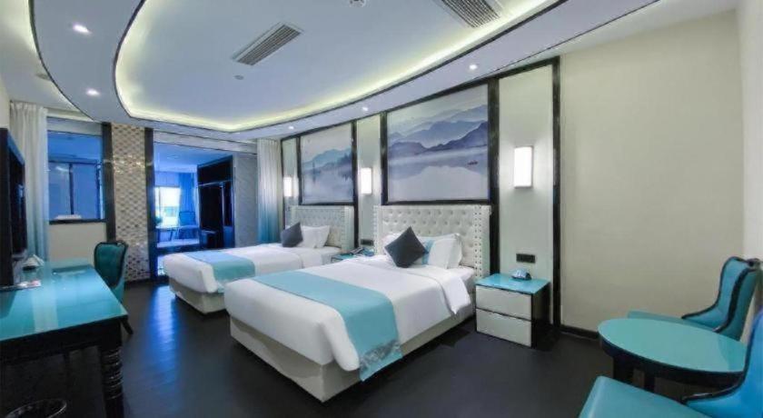 a hotel room with two beds and a desk at Xana Hotelle·Suzhou Shilu Shantang Street Scenic Spot in Suzhou