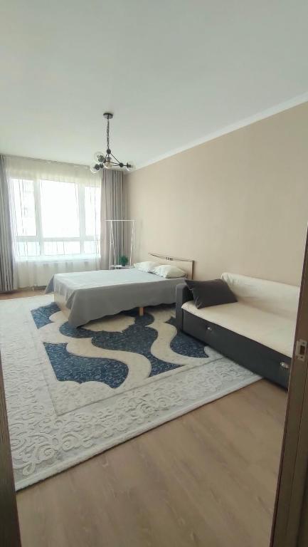 a bedroom with two beds and a rug at Однокомнатные и 2х комнатные квартиры на Туране in Taldykolʼ