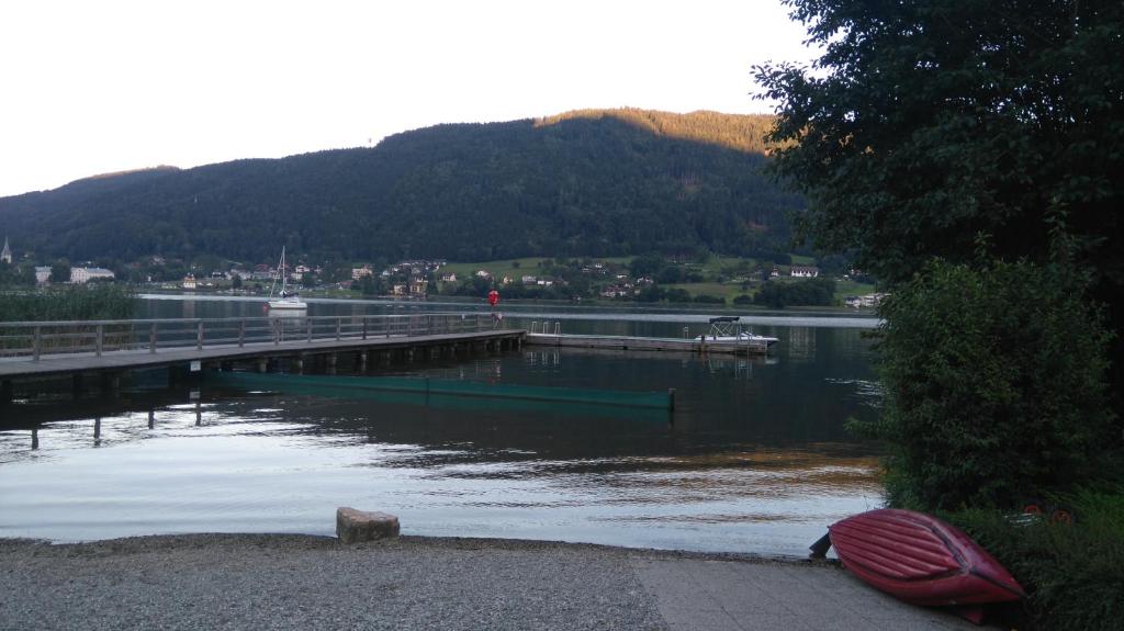 ein Fluss mit einem Pier und einem Boot im Wasser in der Unterkunft Ferienwohnung Christian am Ossiachersee in Bodensdorf