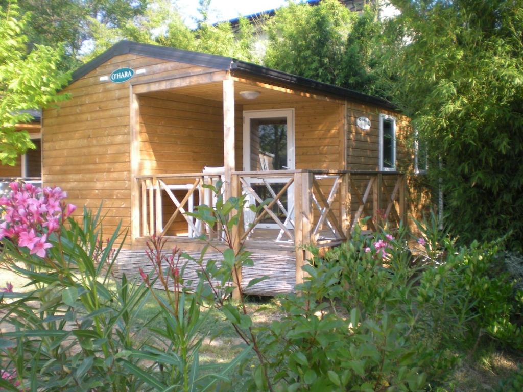 a small wooden cabin with a porch and some flowers at Eco-Lodge Lou Pantaï in Le Pradet