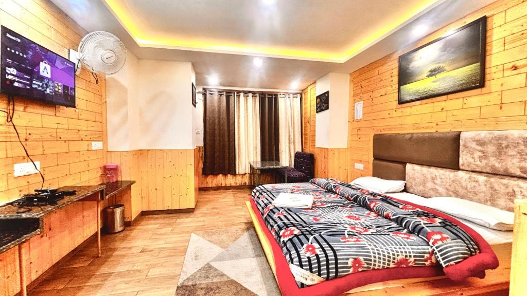 una habitación de hotel con una cama y un televisor en Rajmahal Inn Dalhousie, en Dalhousie
