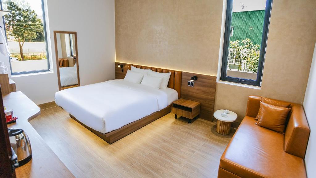 Lien Khuong AirportOne and Only Hotel - Đức Trọng的卧室里有一张白色的床和一张沙发