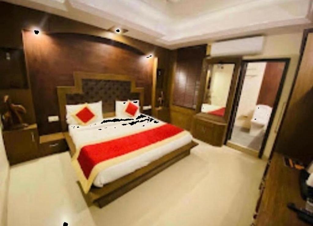 Un dormitorio con una cama grande y un espejo. en Staylo master Inn, en Lucknow