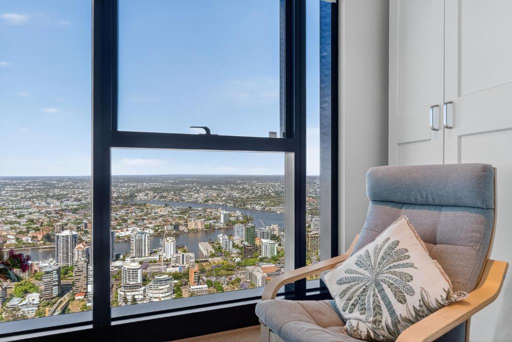 Una sala de estar con una silla y una ventana grande. en Oasis Retreat on Level 71 in Skytower, en Brisbane