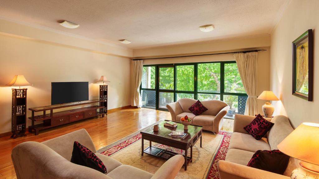 a living room with couches and a tv at Mayfair Hanoi in Hanoi