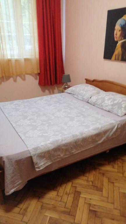 a bed in a bedroom with a wooden floor at апартамент Климент in Varna City