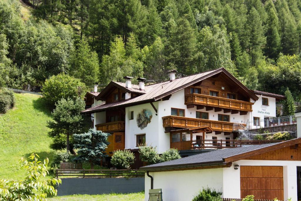 uma casa nas montanhas com árvores ao fundo em Gästehaus Stefan Klotz em Sölden